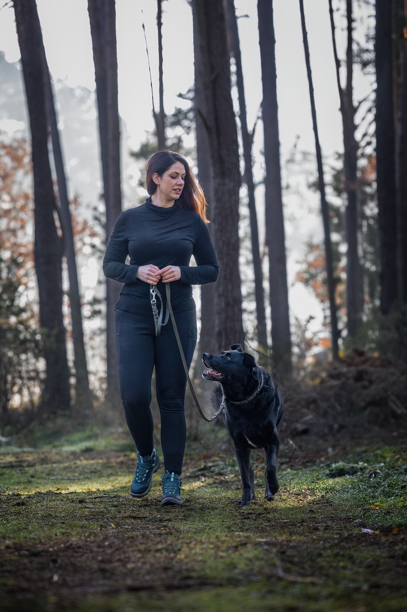 Eine Hundetrainerin läuft mit ihrem Hund