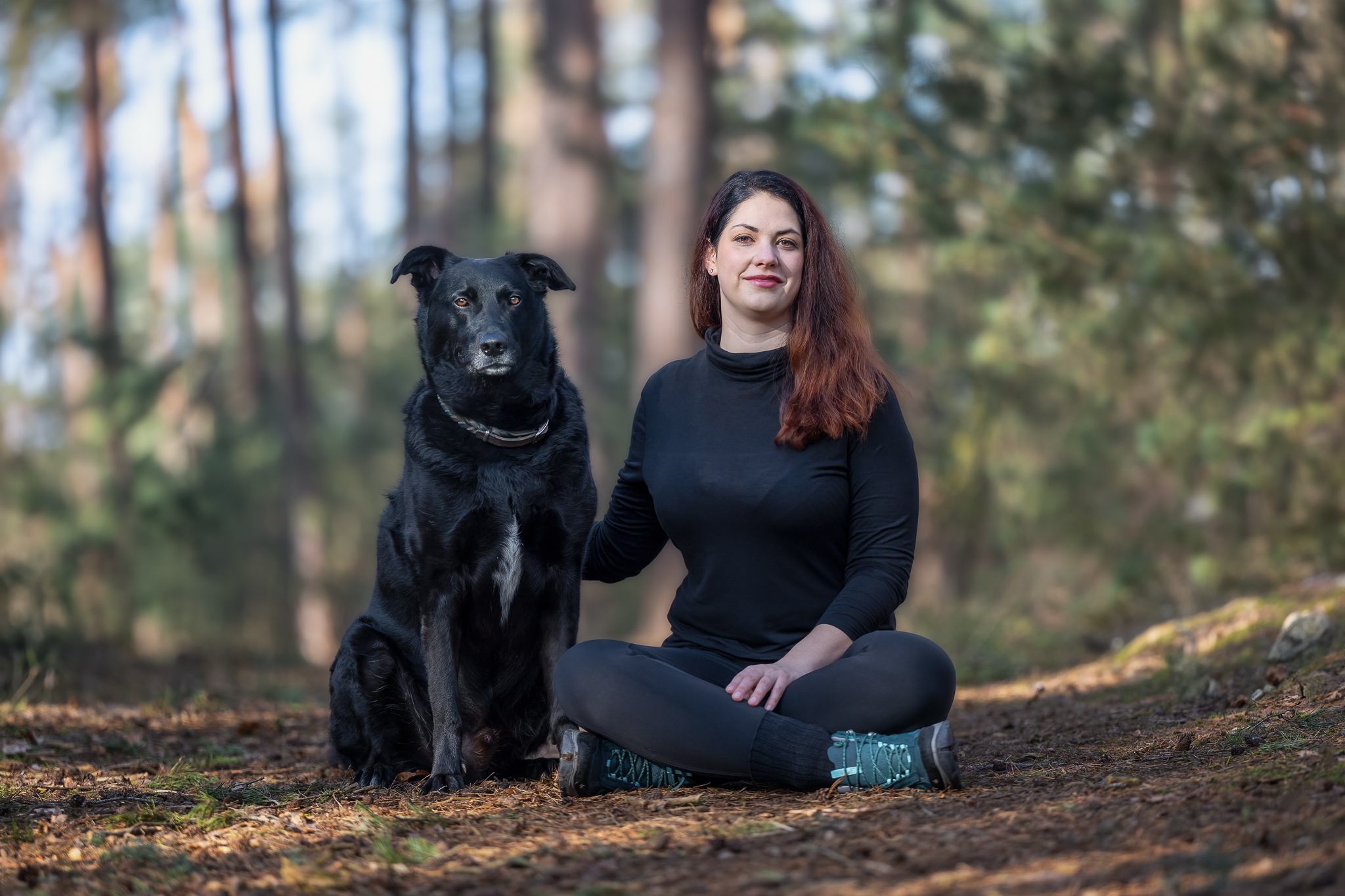 Eine Frau sitzt neben ihrem Hund